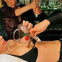 Two dominating ladies play with their female slave in bar... The